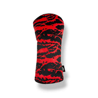 A golf club headcover with a bold red and black abstract tiger-stripe pattern, shown on a clean white background with a soft drop shadow.